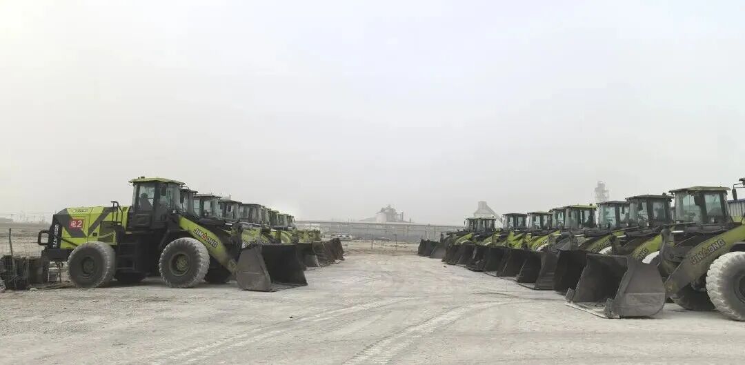Row of green JGM electric wheel loaders staged at a Chinese chemical plant